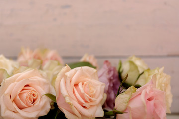 Pink roses on the wooden desk. Flat lay rose flower with leaves frame.
