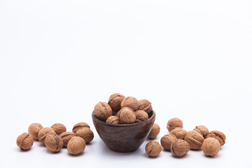 Walnuts in wooden bowl isolated on white background
