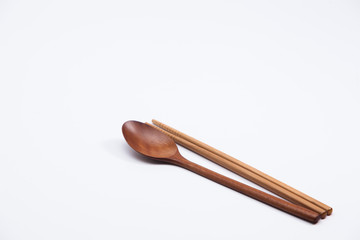 Wooden spoon and chopsticks on white background