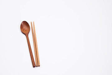 Wooden spoon and chopsticks on white background