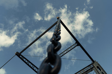 Fototapeta premium iron chain pointing to the blue sky, unique iron bridge