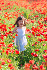 Naklejka na ściany i meble child girl with hat in a flower field