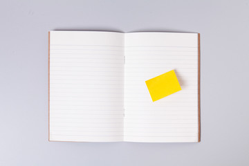 Yellow sticky post note on open note book