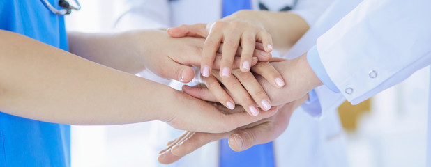 Obraz premium Group of doctors putting their hands together. Close-up