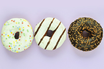 Delicious donuts on light pastel color background.