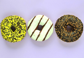 Delicious donuts on light pastel color background.