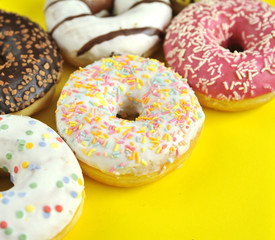 Delicious donuts on light pastel color background.