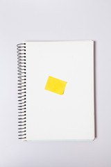  Yellow sticky post note on blank note pad