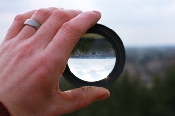 lens in handrevealing or inverting landscape behind