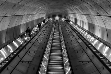 Commuters take a long escalator out of an underground subway station in Washington DC at night