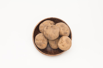 Raw Potatoes on wooden plate