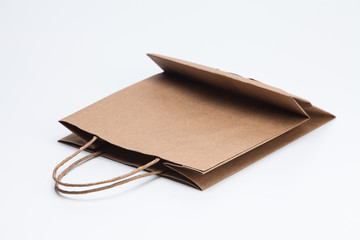 Brown kraft paper shopping bag lying on white 