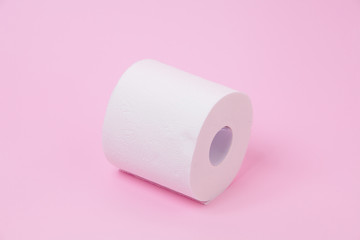 The roll of white toilet tissue paper on pink background