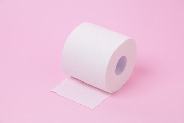 The roll of white toilet tissue paper on pink background