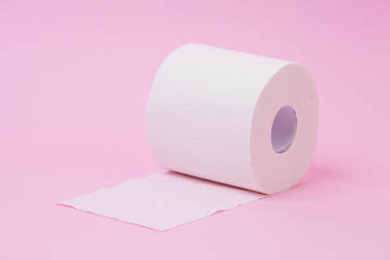 The roll of white toilet tissue paper on pink background
