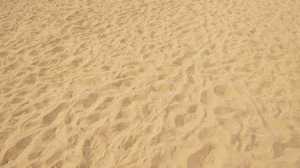 Fototapeta na wymiar Сloseup of sand pattern of a beach in the summer.Sand texture. Sandy beach for background. Top view