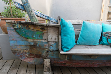 Fototapeta na wymiar Recycling: altes Boot als Sitzmöbel mit türkisen Kissen