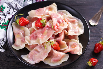 Dumplings, filled with strawberries. Varenyky, vareniki, pierogi, pyrohy - dumplings with filling