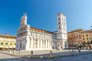 Chiesa di San Michele in Foro St Michael Roman Catholic church basilica on Piazza San Michele square in historical centre of old medieval town Lucca in summer day with clear blue sky, Tuscany, Italy - obrazy, fototapety, plakaty