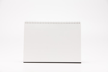 A white paper calendar stands on the table in photo
