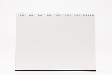 A white paper calendar stands on the table in photo