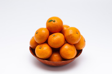 Orange tangerines on a wooden bowl on a white background