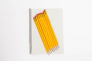 Fototapeta premium A Bunch of yellow pencil and binder notebook on white
