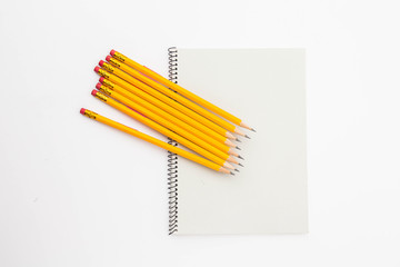 A Bunch of yellow pencil and binder notebook on white