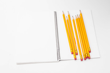 A Bunch of yellow pencil and binder notebook on white