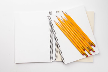A Bunch of yellow pencil and binder notebook on white