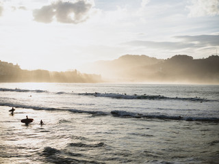 Surfers getting out of the water in San Sebastian
