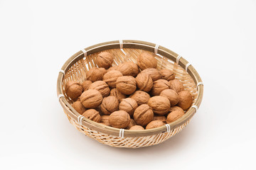 Walnuts in bamboo traditional asian kitchen basket food tool on white