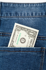 One dollar bill in the back pocket of blue jeans