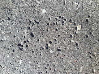 Asphalt grey background with black dots. White blotches chaotically on grange surface . Dust abstract texture for backdrop.