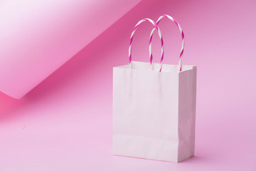 White shopping bag on abstract pink background for design
