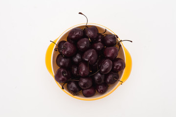 Fresh red cherries on yellow bowl