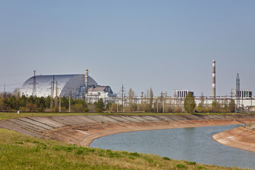 Obraz premium nuclear reactors of Chernobyl power plant next to Pripyat river, 4th (exploded) reactor with sarcophagus on left, 3th reactor on right, Exclusion zone, Ukraine