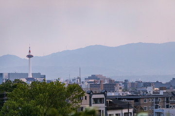 Fototapeta na wymiar Large modern tower stands over buildings in typical Japanese neighborhood before sunset