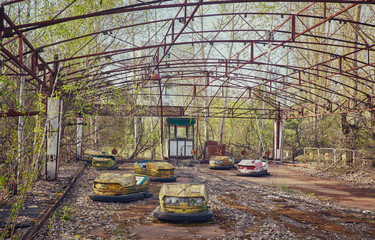 abandoned bumper cars in ruined amusement park in Pripyat city, Exclusion zone of Chernobyl, Ukraine