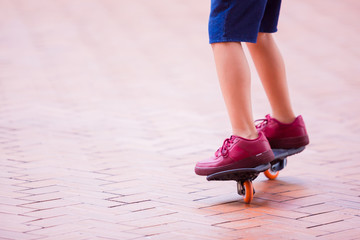 selective focus to boy skateboarder is skateboarding and riding on red brick street.