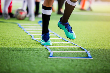 Soccer player jogging and jump between marker for football training with blurry other players...