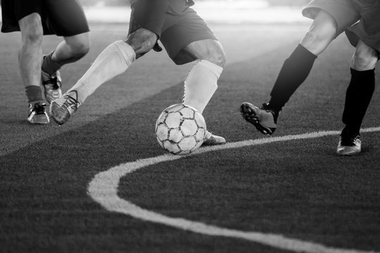black and white image of soccer players trap and control the ball for shoot to goal.