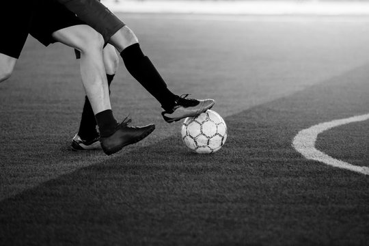 black and white image of soccer players trap and control the ball for shoot to goal.