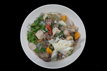 Meat soup in white bowl isolated on black background