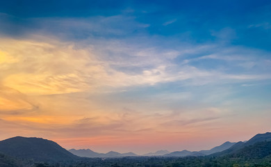 Landscape of mountain range with beautiful sunset sky. Mountain with fog in the evening. Colorful sky and clouds at sunset. Mountain valley in Thailand. Scenery of mountain layer at dusk.