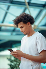 Young man looking away while talking on mobile phone in cafe