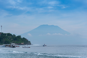 beautifull view on Bali from beach, early morning with fogs in front of Agung mount vulcano, blue sky background