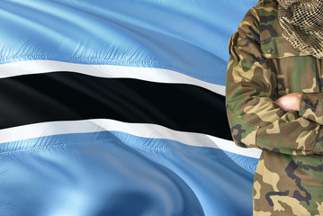Crossed arms soldier with national waving flag on background - Botswana Military theme.