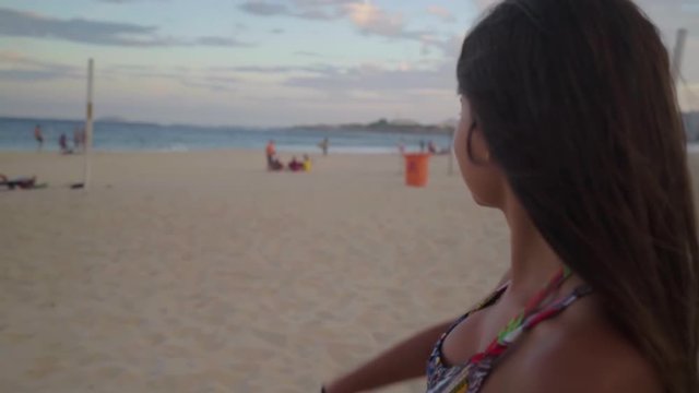 Slow Motion: Beautiful Woman on Beach Smiles then Points to Distant Shoreline - Rio de Janeiro, Brazil