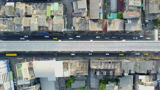 4K. Aerial view of skytrain railroad over two-way urban road in Bangkok, Thailand. Land transport railway in the city. 